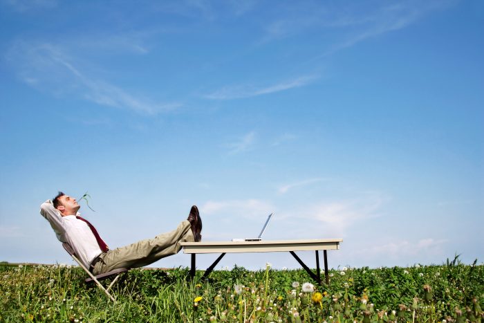 Man-relaxing-in-field-700x467